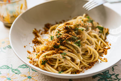 Homemade italian pasta dish known as pasta con le sarde on table cloth