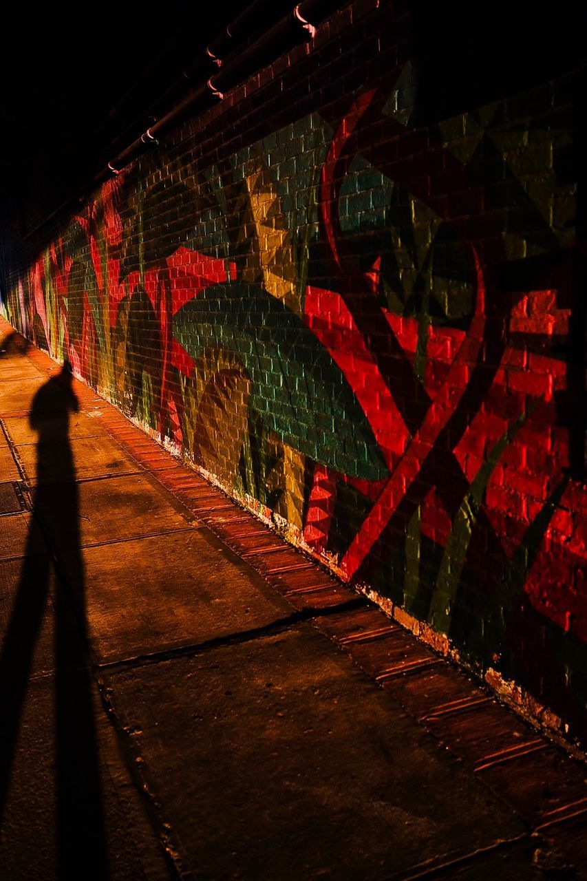 architecture, night, illuminated, red, one person, built structure, real people, direction, footpath, the way forward, tunnel, transportation, lighting equipment, lifestyles, wall - building feature, subway, outdoors, wall, brick, underpass