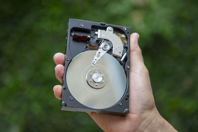 Midsection of person holding hard disc drive