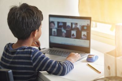 Rear view of boy using mobile phone