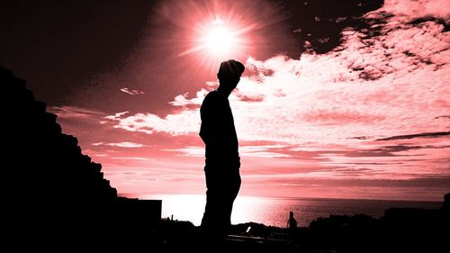 Silhouette of woman standing against river