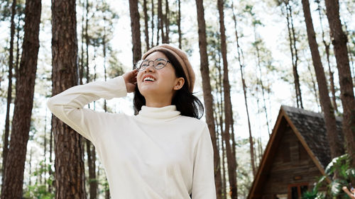 Excited asian woman looking around the forest. lifestyle of single woman travel around the world.