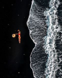 Aerial view of young woman lying down on shore