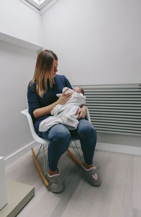 Mother feeding son with milk bottle