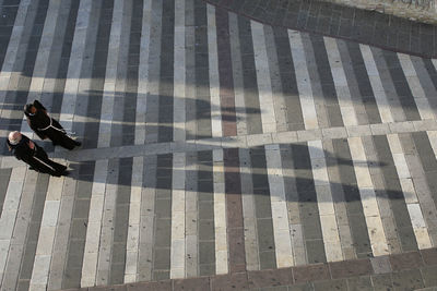 High angle view of people walking on tiled floor