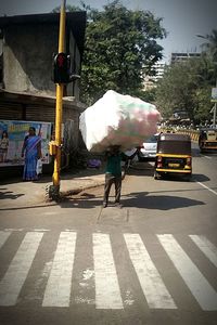 Rear view of man walking on road in city