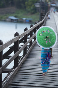 Rear view of a woman walking with umbrella