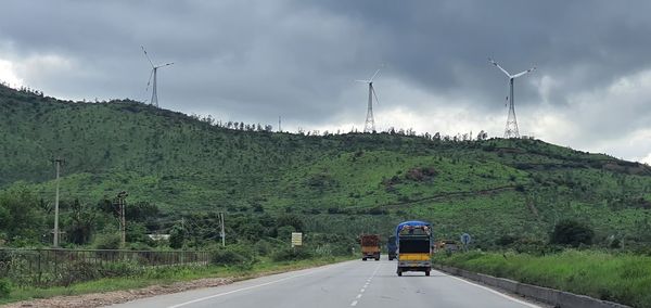 Rear view of vehicles on road against sky