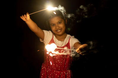 A cute indian girl child enjoying sparklers during diwali festival