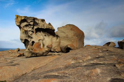 Rock formations on landscape against cloudy sky