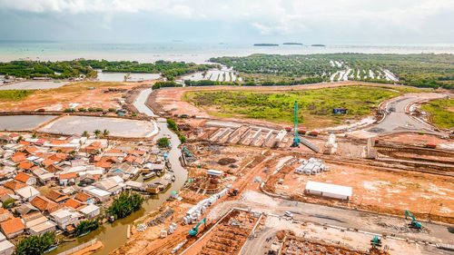 High angle view of city by sea against sky