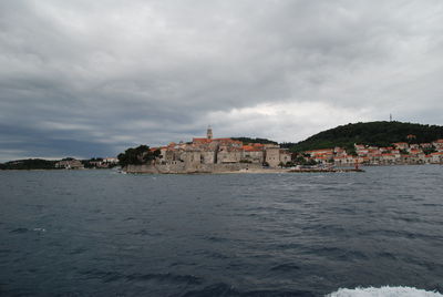 Scenic view of sea by city against sky