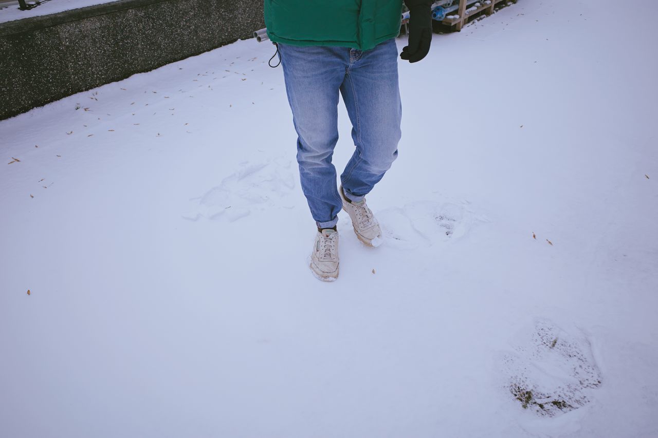 LOW SECTION OF MAN STANDING ON SNOW