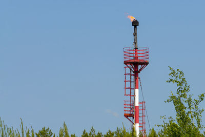 Low angle view of communications tower against clear blue sky