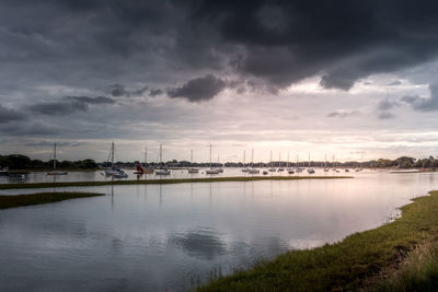 Boats in harbor with a dramatic, cloudy sky