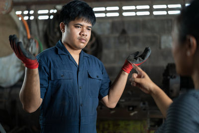 Midsection of woman pointing at angry young man