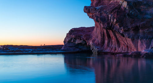 Scenic view of rock formation in sea against sky