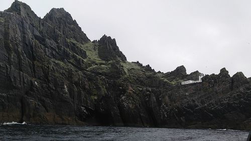 Rock formations by sea against clear sky