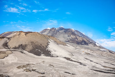 Scenic view of snowcapped mountains against blue sky