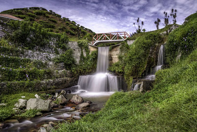 Scenic view of waterfall against sky