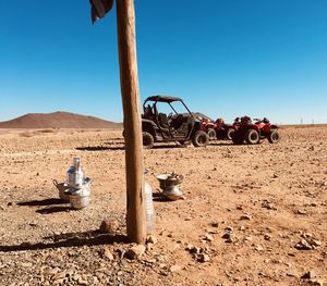 Tractor on field against clear blue sky