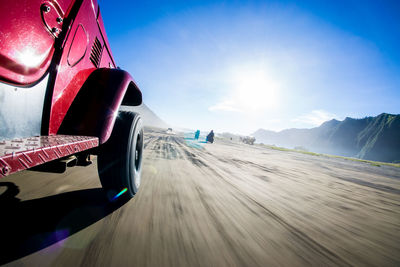 Cropped image on vehicle moving on street against sky during sunny day