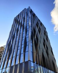 Low angle view of modern building against clear blue sky