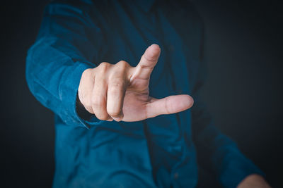 Midsection of man making face against black background