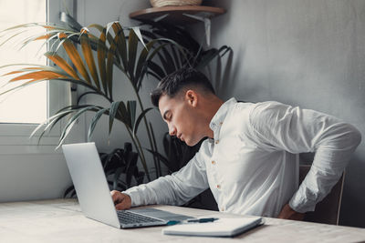 Young woman using laptop at table