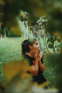 Portrait of young woman looking away on tree