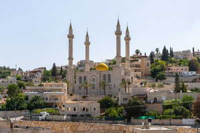 Buildings in city against clear sky