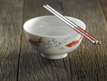 Close-up of empty bowl and chopsticks on table