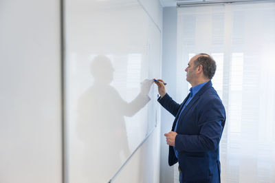 Manager in office writing on white board