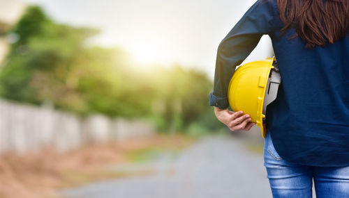 Rear view of woman holding yellow umbrella