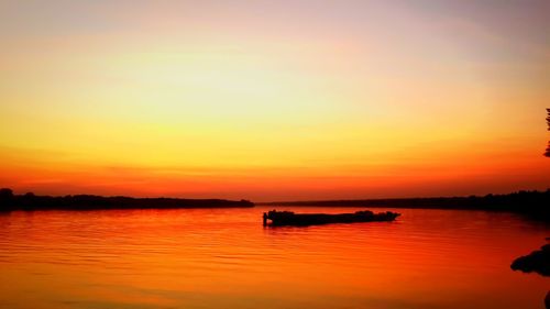 Scenic view of lake against romantic sky at sunset