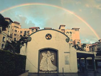 View of rainbow over buildings in town