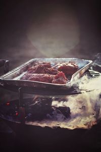 Meat in tray on barbecue grill