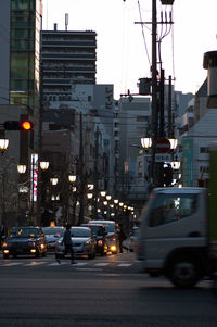 Traffic on city street against amidst buildings in city