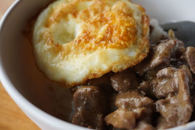 Rice, egg and beef in the bowl for breakfast shot directly above and close-up