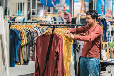 Man choosing t-shirts at store