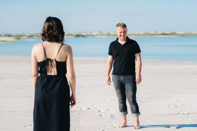 Rear view of friends standing on beach