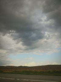 Scenic view of field against cloudy sky