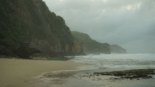 Scenic view of sea and mountains against sky