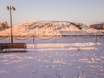 Snow covered landscape against clear sky