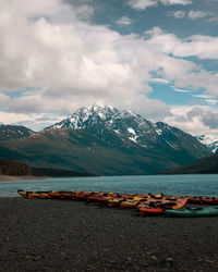 Scenic view of lake by snowcapped mountains against sky