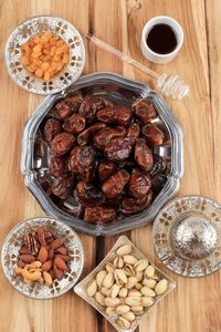 Snack for ramadan or eid mubarak, dates fruit, almond, raisins, honey, and pistachio. 