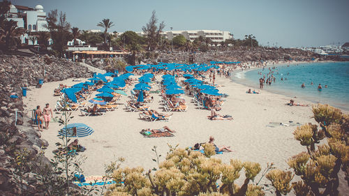 Lounge chairs at beach against sky in city