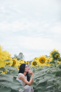 Full length of woman with sunflower against sky