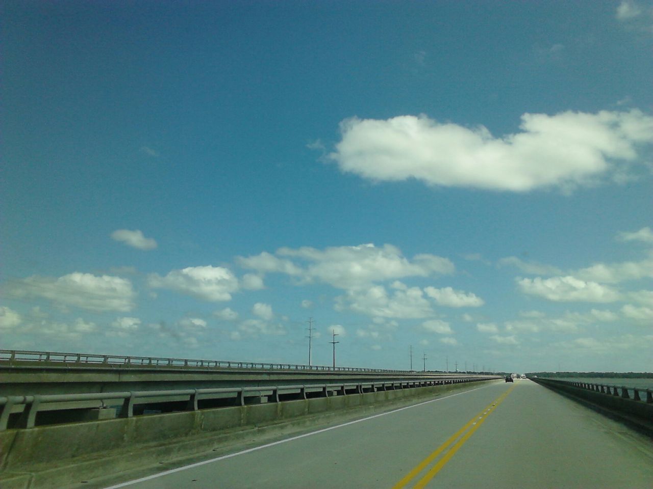 the way forward, transportation, road, road marking, sky, diminishing perspective, vanishing point, cloud - sky, built structure, highway, connection, street, long, empty, cloud, architecture, asphalt, railing, blue, car