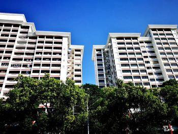 Low angle view of buildings against clear blue sky